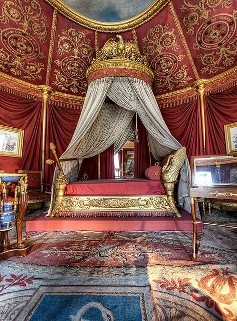 an elaborately decorated bedroom with red and gold decor