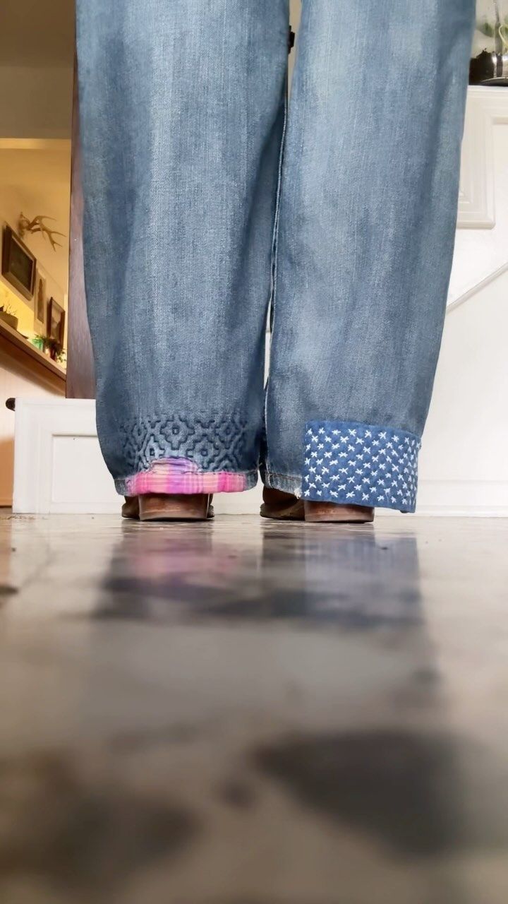 a person standing on the ground with their legs crossed and wearing blue jeans, pink shoes