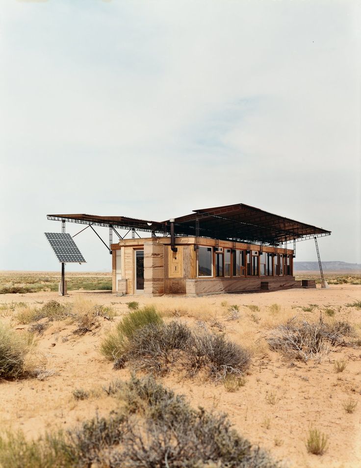 a small building in the middle of an open field with a solar panel on top