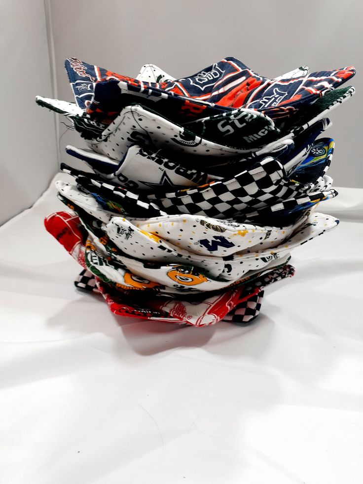 a stack of cloths sitting on top of a white table next to each other