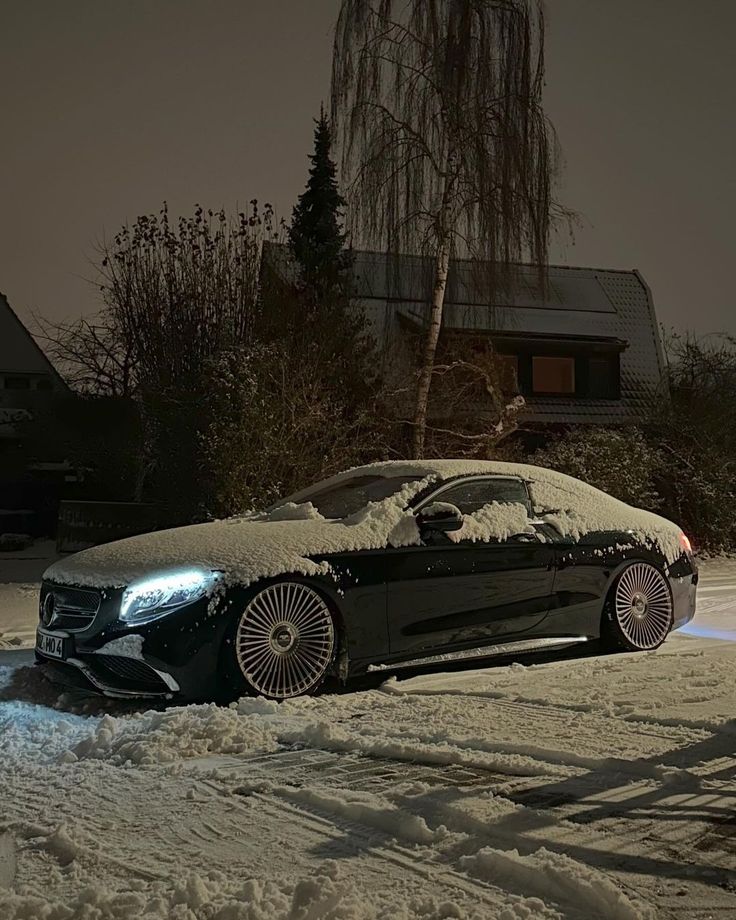 a car is covered in snow at night