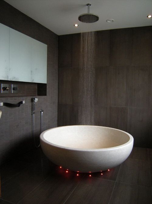 a large white bath tub sitting on top of a wooden floor