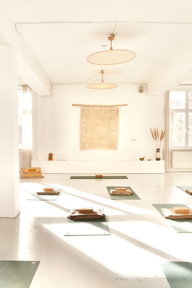 there are many yoga mats on the floor in this room with sunlight coming through the windows