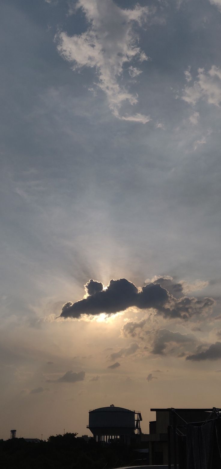 the sun is setting behind some clouds in the sky