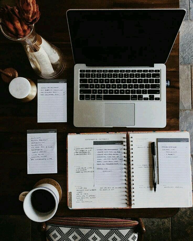 an open laptop computer sitting on top of a desk next to a cup of coffee