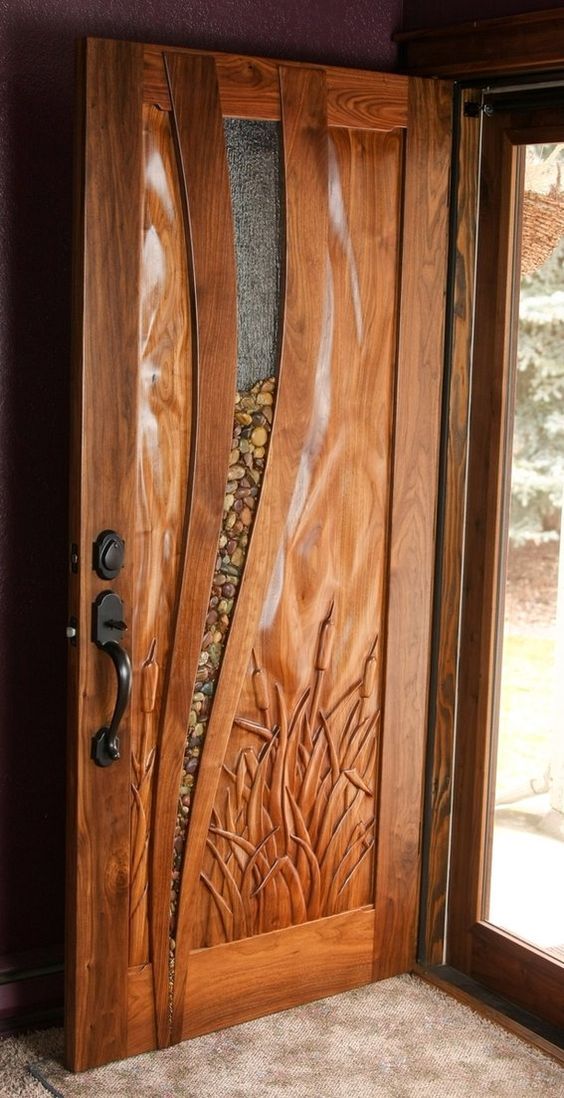 the front door is made out of wood and has an intricate carving pattern on it