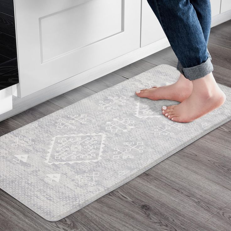 a person standing on the floor in front of an oven with their feet propped up