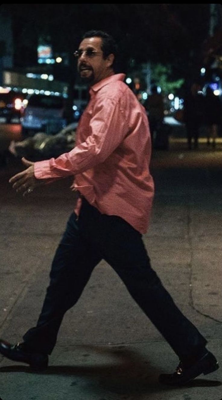 a man walking down the street with his arms out in front of him and one hand outstretched