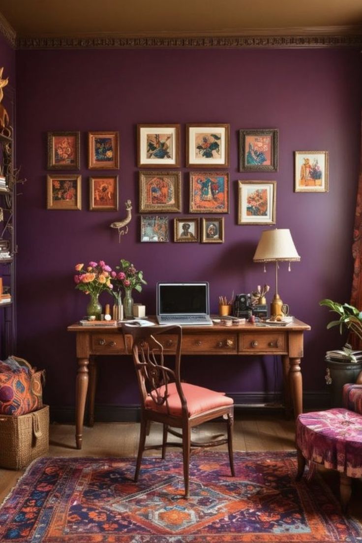 a purple room with pictures on the wall and a desk in front of a chair