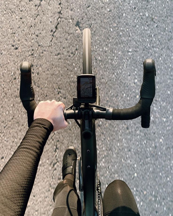 a person riding a bike with their hand on the handlebars