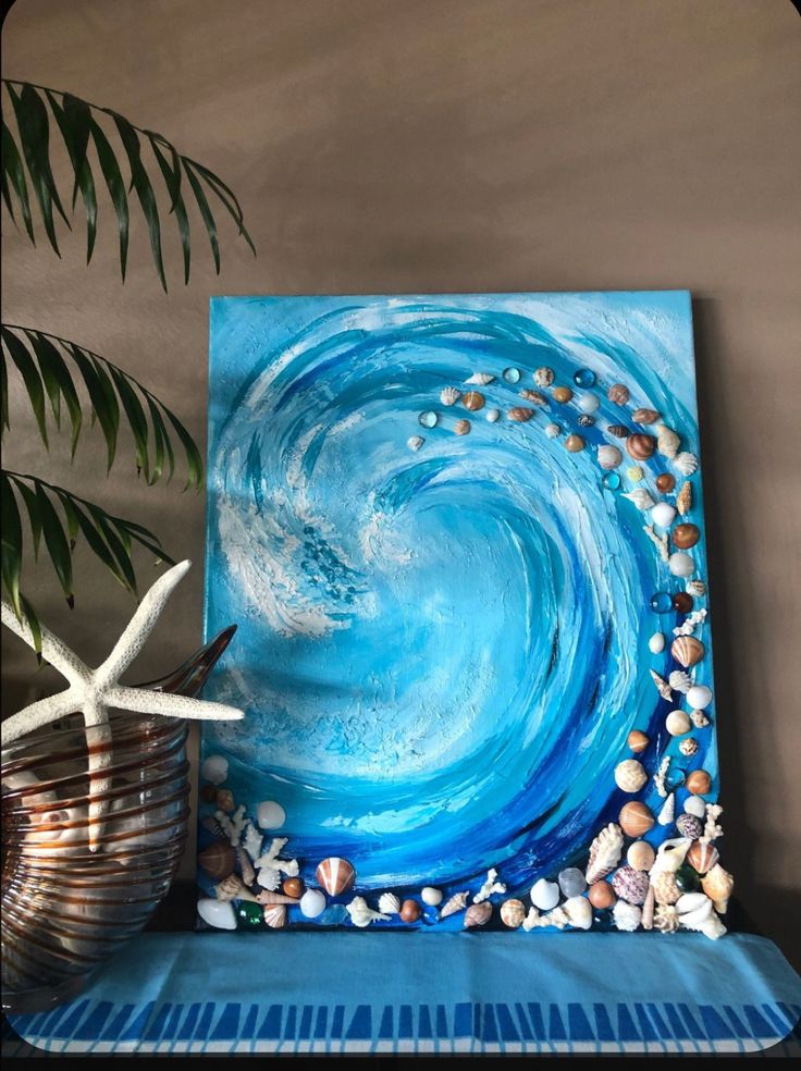 a blue painting with shells and starfish on it next to a potted plant