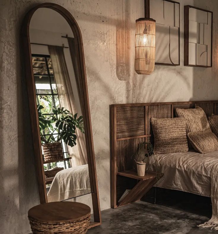 a bed sitting next to a large mirror in a room with wooden furniture and decor