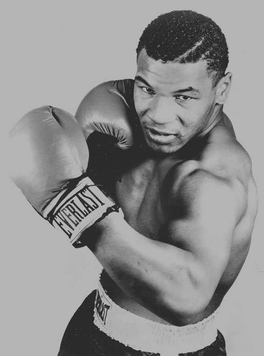 a black and white photo of a man wearing boxing gloves