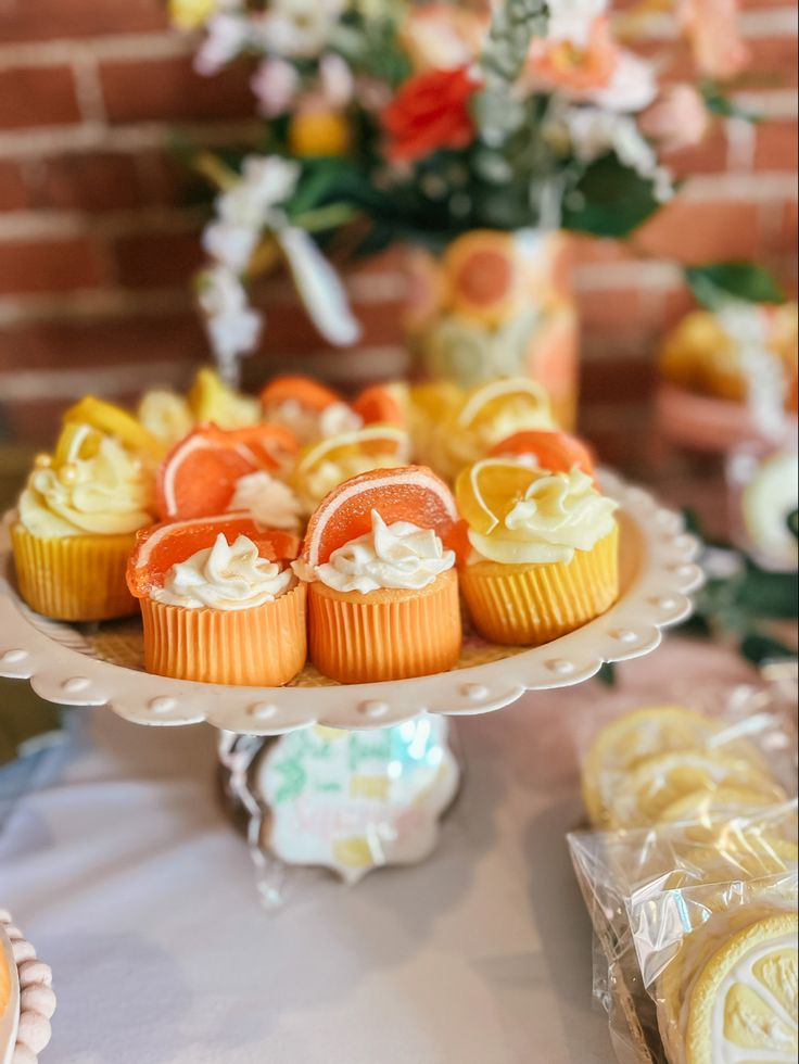 cupcakes and orange slices on a cake plate