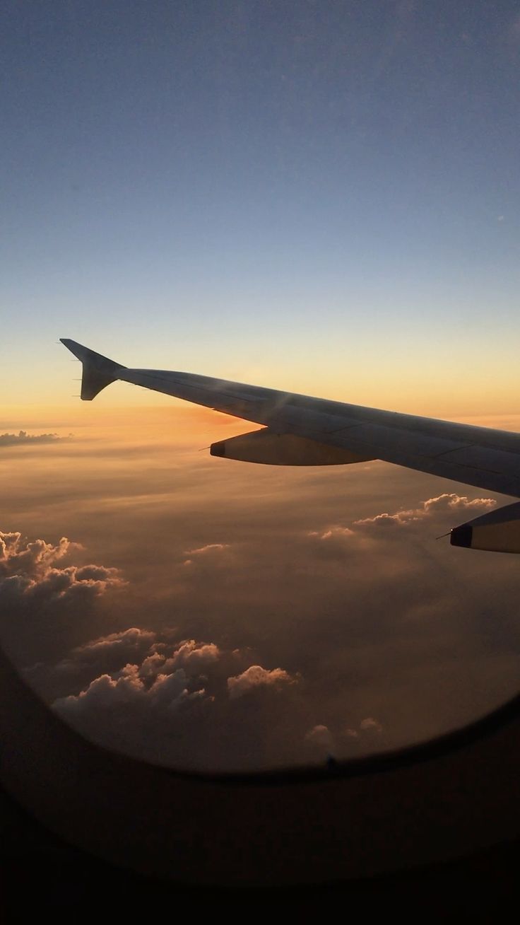 the wing of an airplane as it flies over clouds