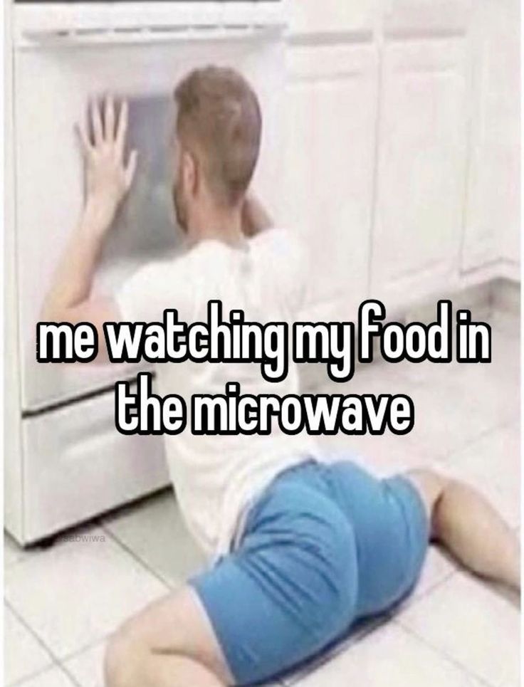 a man sitting on the floor in front of an oven with his hand up to it