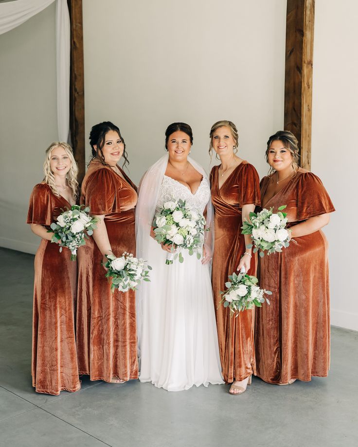 the bride and her bridesmaids are all dressed in brown velvet dresses for their wedding