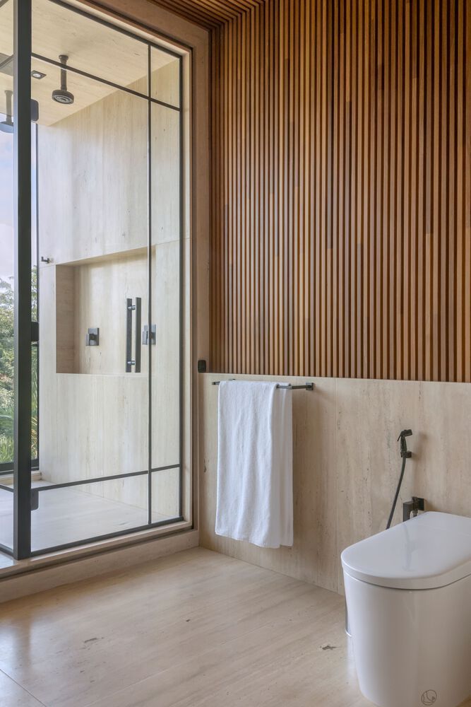 a bathroom with wooden walls and flooring next to a glass shower door that leads out onto a balcony