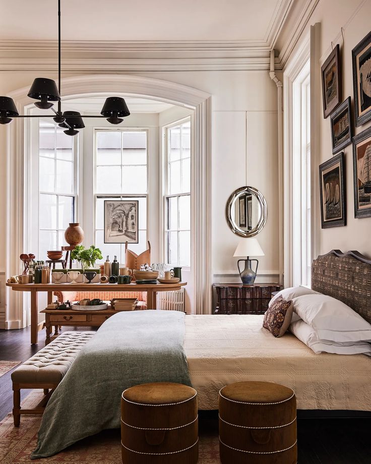 a large bed sitting in a bedroom on top of a hard wood floor next to two windows