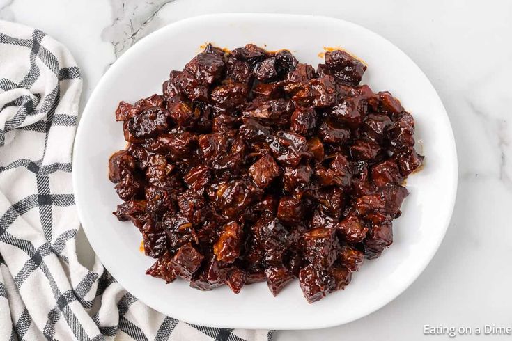 raisins in a white bowl on top of a black and white checkered towel