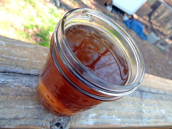 a jar filled with liquid sitting on top of a wooden table