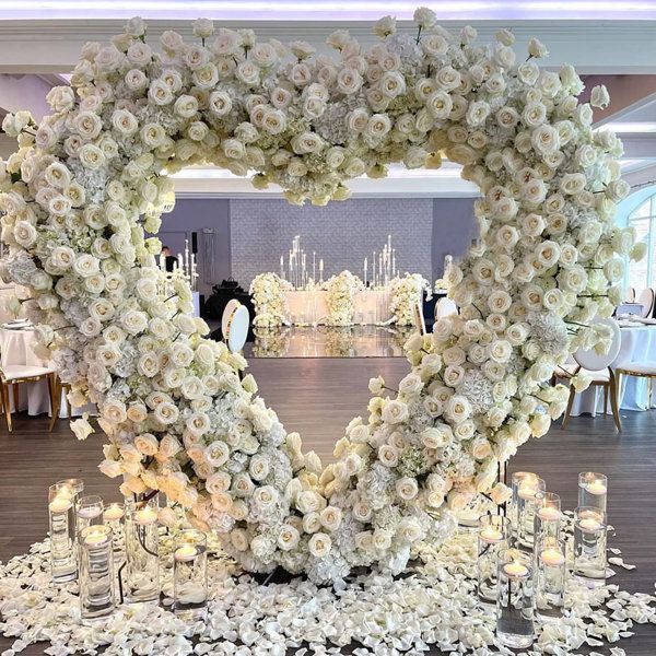 a heart - shaped arrangement of flowers and candles is on display at a wedding reception