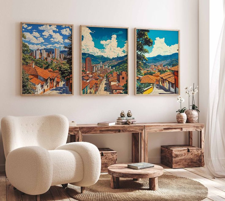 two paintings hang on the wall above a white chair and table in a living room