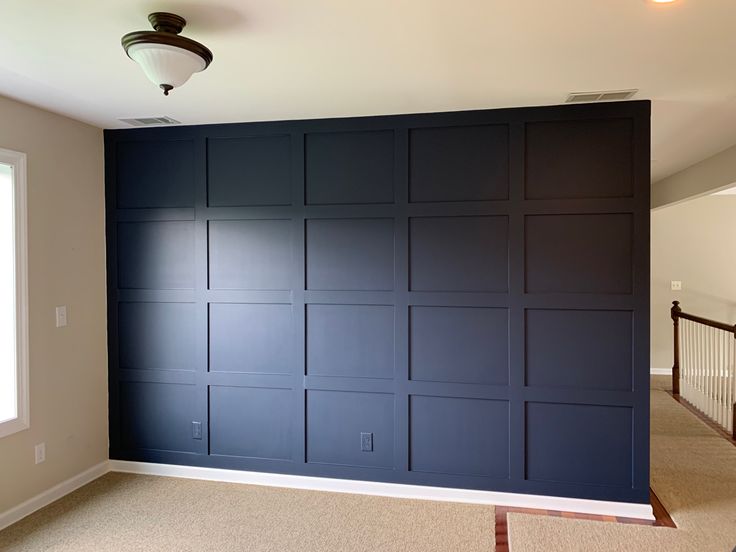 an empty room with dark blue walls and white trim on the wall is pictured in this image