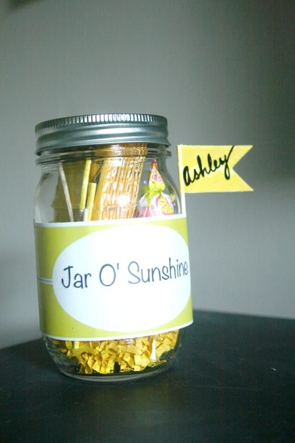 a jar filled with yellow flowers sitting on top of a wooden table next to a sign that says jar o sunshine