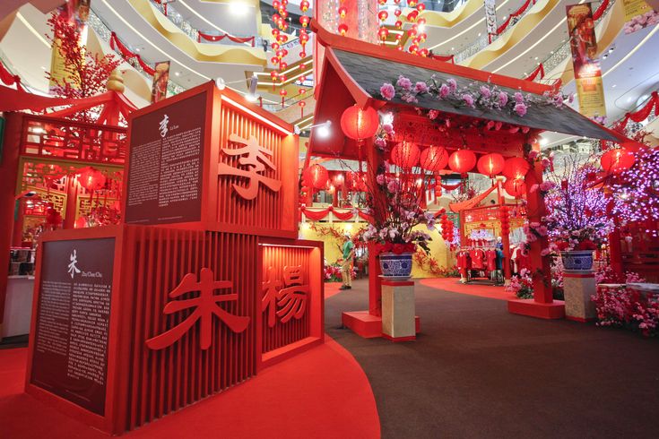 the entrance to a chinese restaurant decorated in red and yellow colors with lanterns hanging from the ceiling