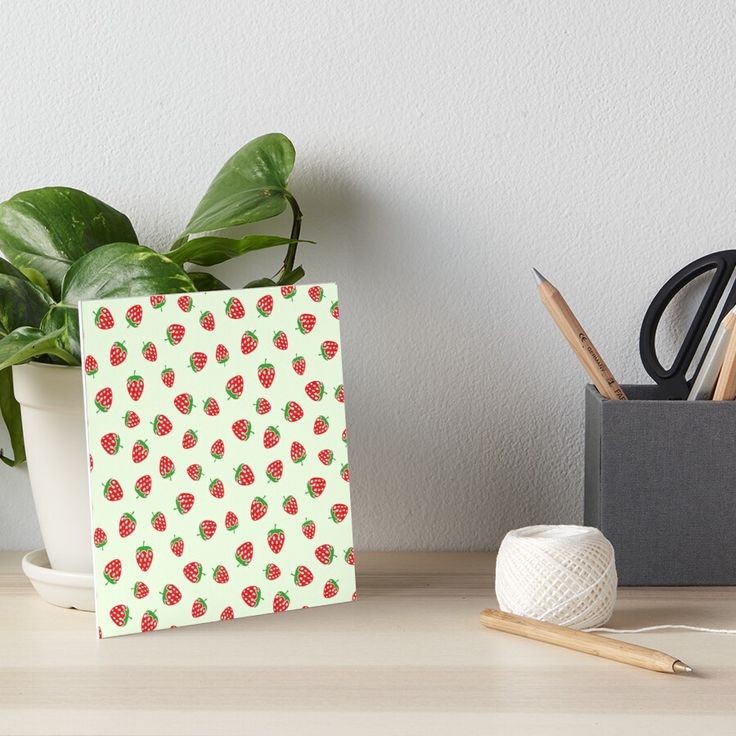 a white and yellow pattern with small animals on it art boarder next to a potted plant