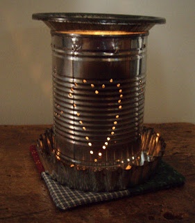 a tin can sitting on top of a wooden table next to a lit candle holder