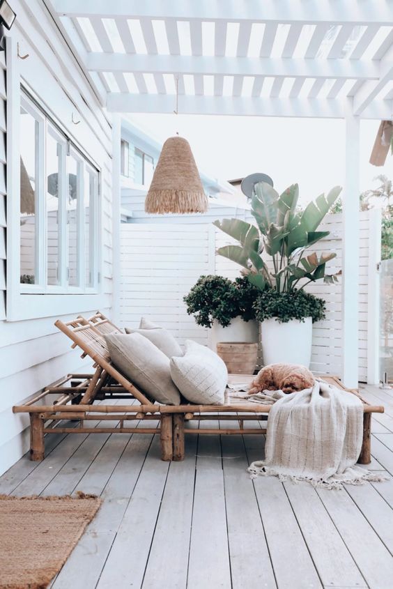 a wooden bench sitting on top of a wooden floor next to a potted plant