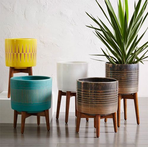 three planters sitting next to each other in front of a white wall and floor