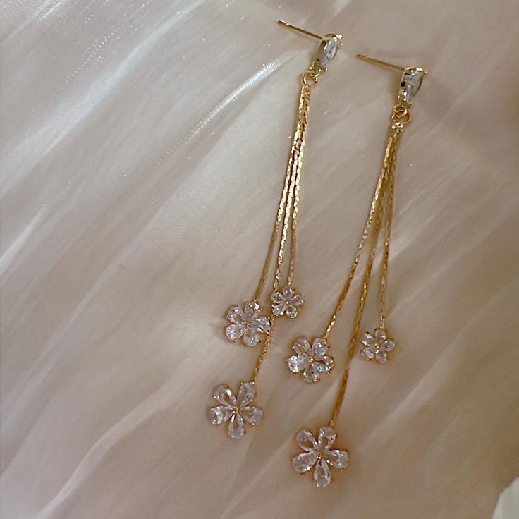 * DETAILS * - Gold Plated CZ Paved Flower Tassels  - Gold Plated Teardrop Shaped Ear Post  👉🏻For more earrings, see https://www.etsy.com/shop/JinnysJewelryBySeJin ------------------------------------------------ * CARE TIPS * ⭐️TO PREVENT TARNISH: Keep your jewellery in airtight plastic bags. It won't tarnish if it isn't exposed to air. The worst place to leave your jewellery is in a steamy bathroom. Wipe with a soft cloth after wearing. - Perfumes: Be sure any perfume or lotions are completely absorbed into skin. - Hair products: Apply all hair products before putting on jewelry. - Swimming: Remove all jewelry before swimming or getting into hot tubes. - No sunlight: Store away from heat, direct sunlight, window sills and vents. - Bedtime: Take off all jewelry before bed - No tissue: Ne Wedding Jewelry: Pearl Charm Drop Earrings, Gold Long Drop Earrings With Pearl Charm, Elegant 14k Gold-filled Bridal Earrings, Gold 14k Gold-filled Dangle Bridal Earrings, Gold Pear-shaped Bridal Earrings With Pearl Charm, Gold Wedding Jewelry, Tassel Drop Earrings, Bridal Earrings Pearl, Special Jewelry