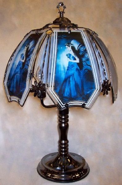 a lamp that is on top of a wooden stand with an image of a woman