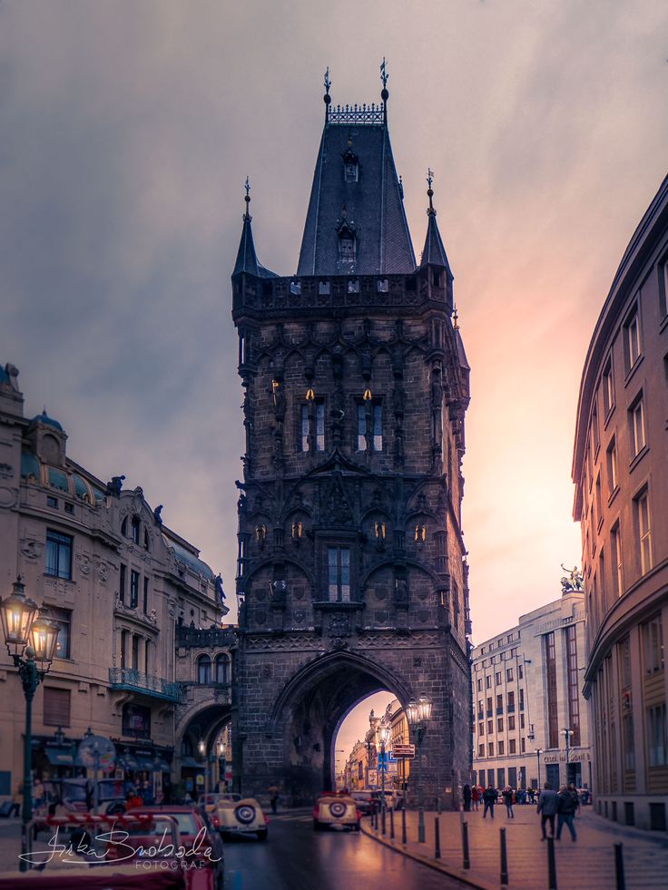 an old stone building with a clock tower on it's side in the evening