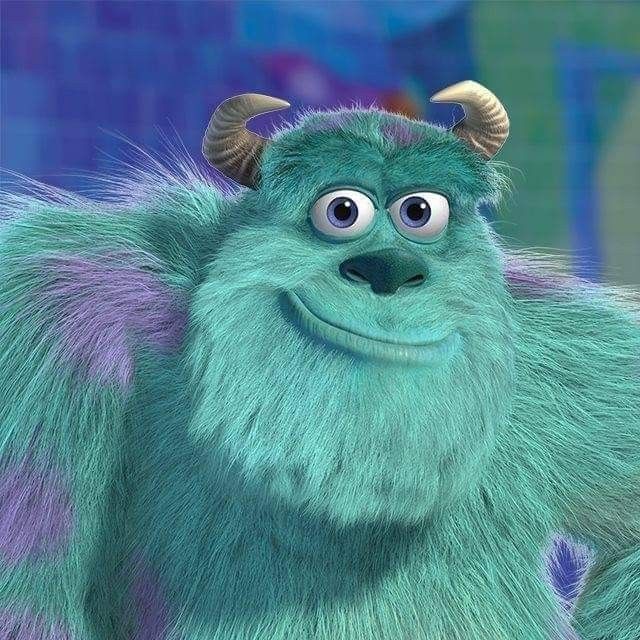 an animated blue and green monster with horns on it's head, looking at the camera