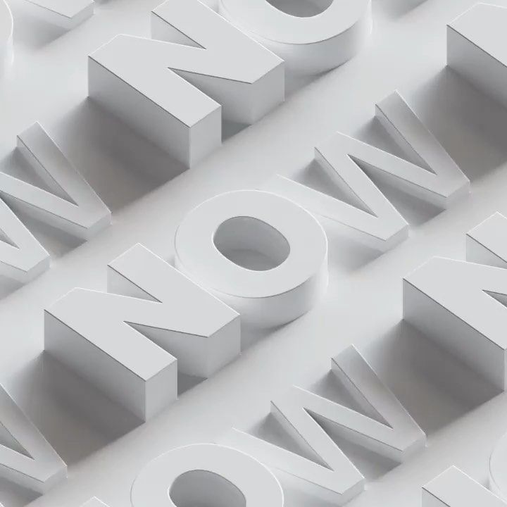 the word now spelled with white letters on a white background that appears to be made out of paper