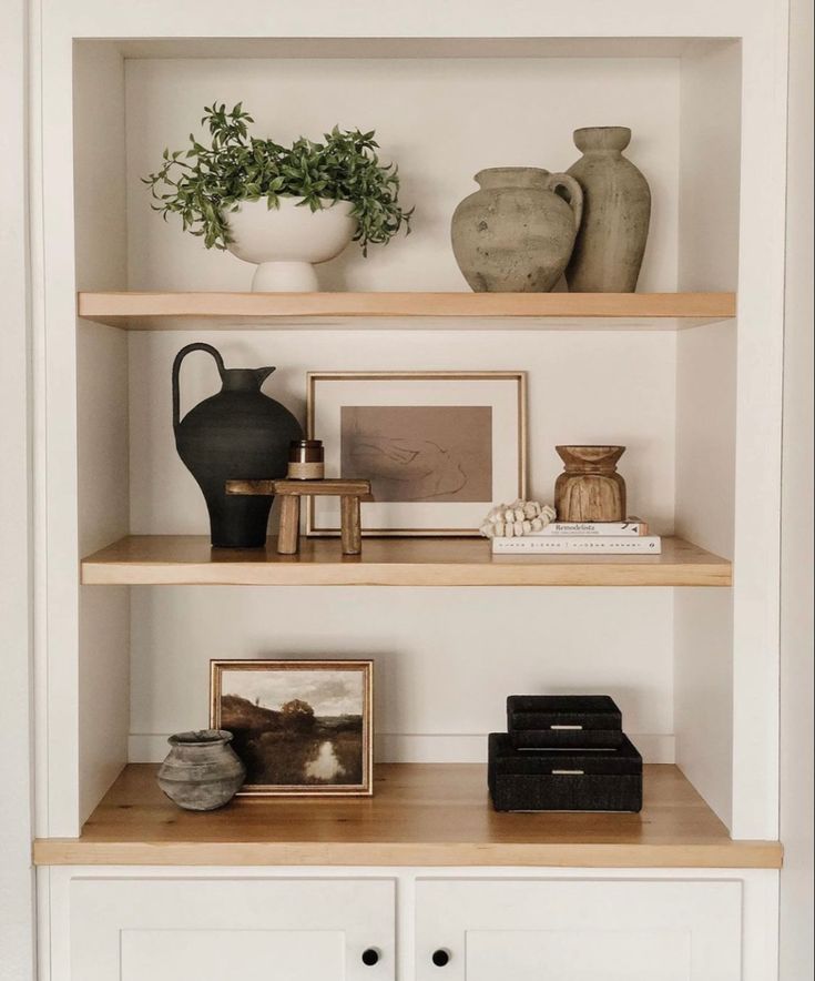 some shelves with vases and pictures on them