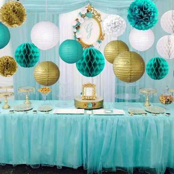 a table topped with lots of paper lanterns next to blue and gold decorations on top of it