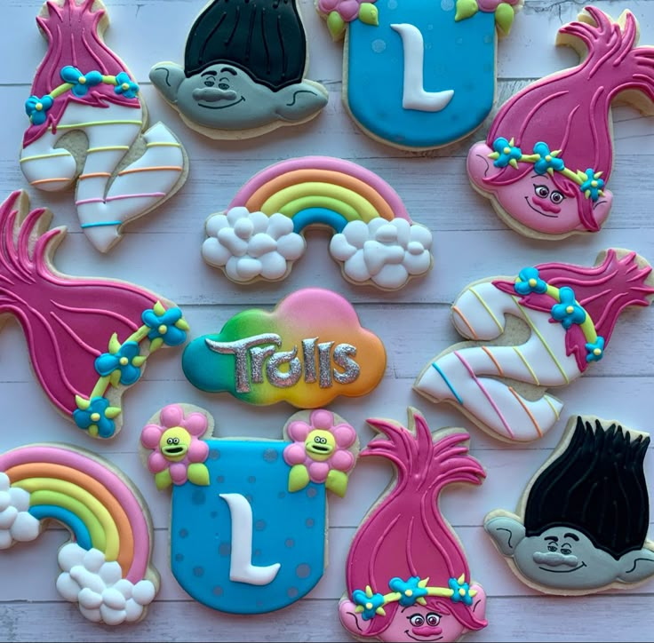 decorated cookies are arranged in the shape of children's books and rainbow - colored letters