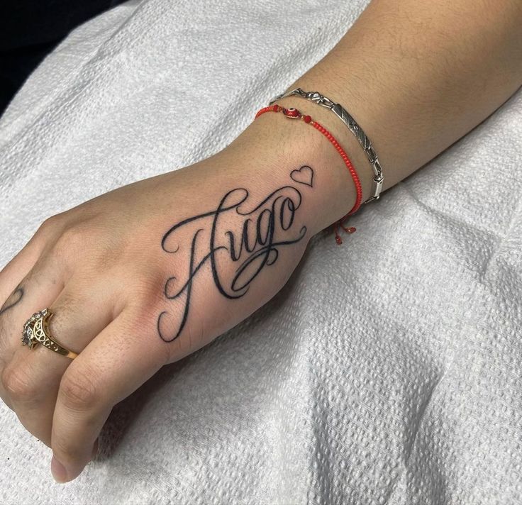 a woman's hand with a tattoo on it and the word hello written in cursive writing