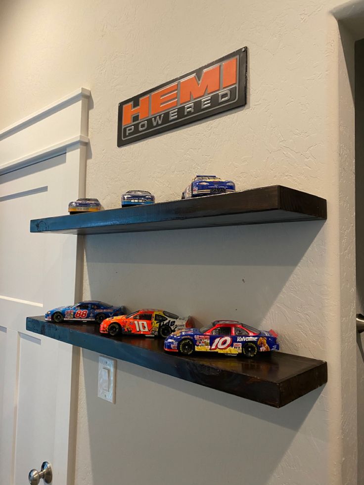 two shelves with racing cars on them in a room