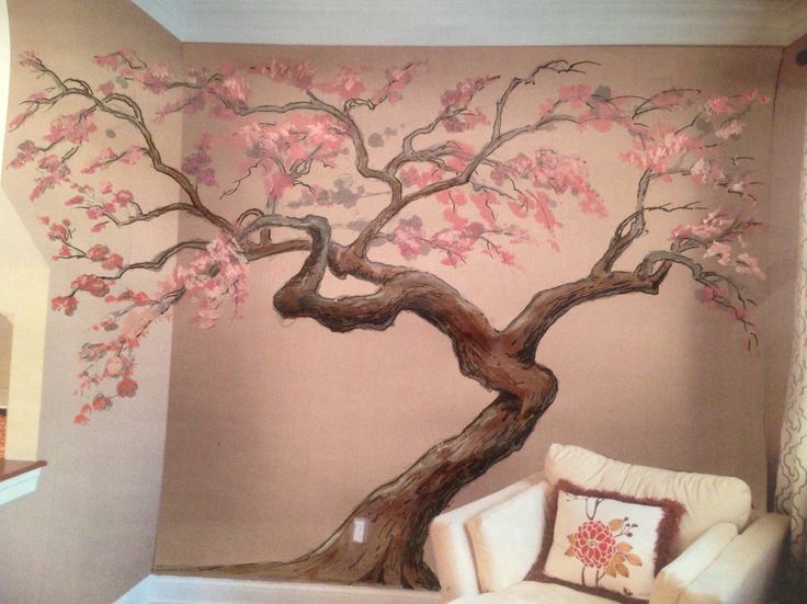 a living room with a tree painted on the wall