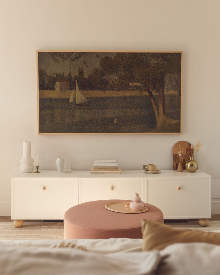 a living room with a painting on the wall and a coffee table in front of it