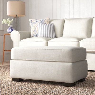 a white couch and ottoman in a living room