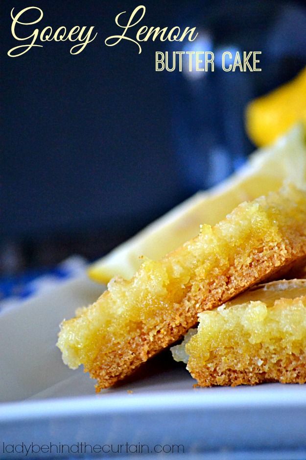 two pieces of cake sitting on top of a white plate next to lemon wedges