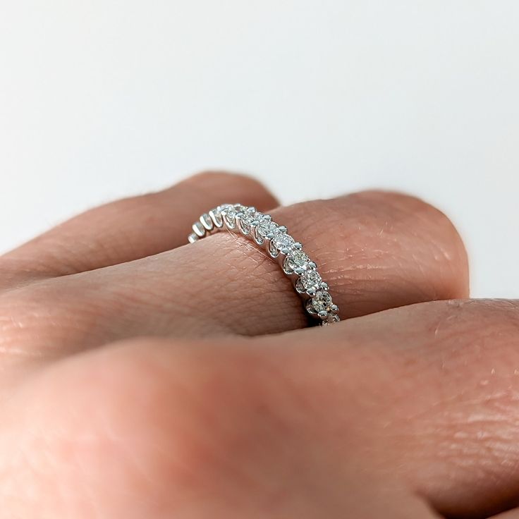 a woman's hand with a diamond ring on her finger, showing the side view