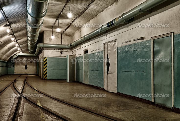 an empty train station with several doors and rails on the floor in front of it